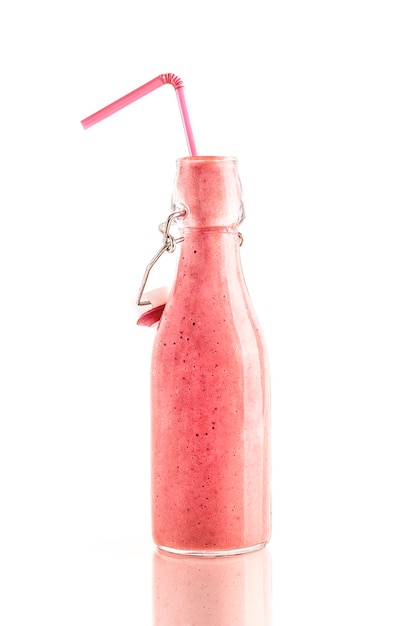 Foto fles heerlijke roze aardbei smoothie met een rietje geïsoleerd op een witte achtergrond. gezond, detox en dieetvoedselconcept.