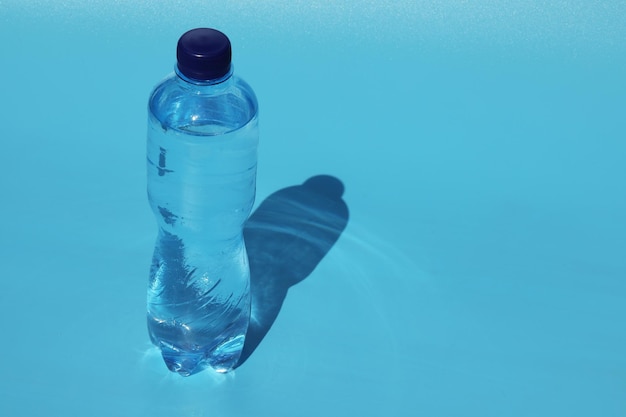 fles koud water op blauwe achtergrond