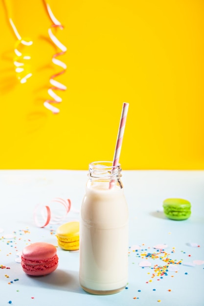 Fles melk en bitterkoekjes op het achtergrondverjaardagsconcept