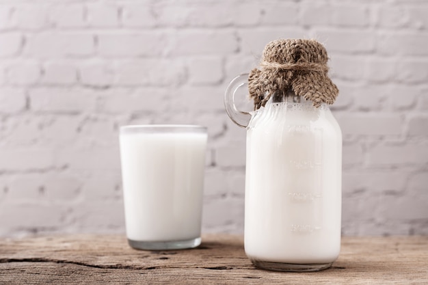 Foto fles melk op houten tafel.