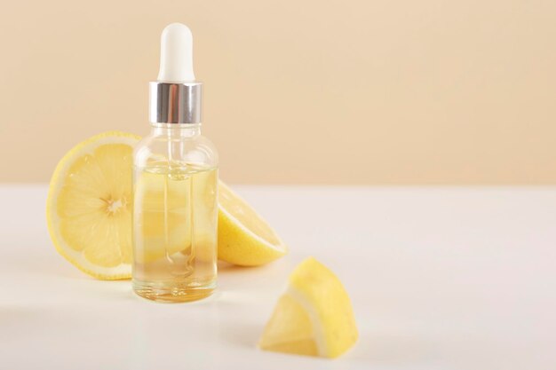 Fles met essentiële citroenolie met schijfjes citroen op tafel Cosmetische citrusolie of serum Natuurgeneeskundig concept Aromatherapie