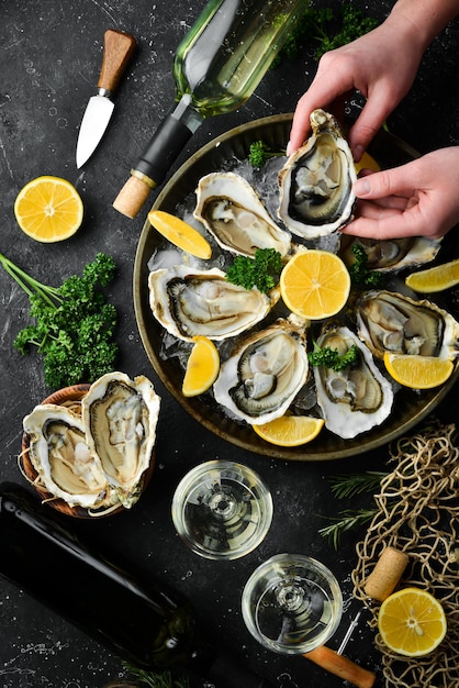 Fles oude wijn en verse oesters op een donkere keukentafel Zeevruchten Bovenaanzicht Plat leggen