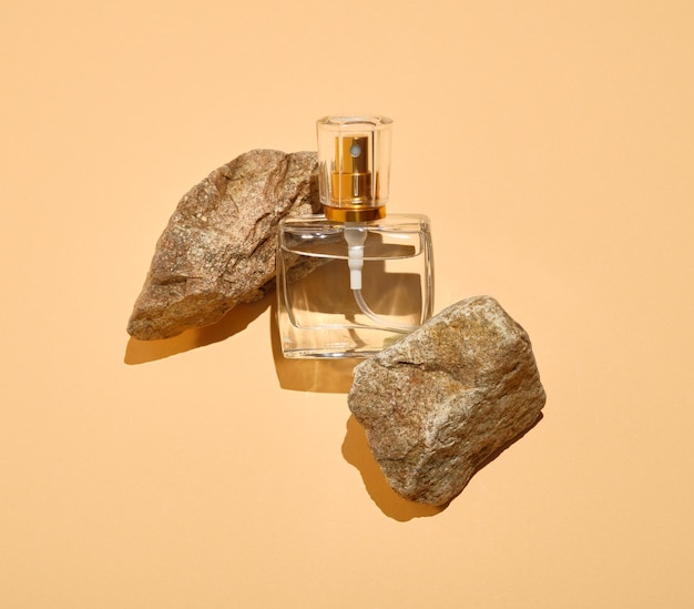 Fles parfum met zomerse natuurlijke geur en stenen. Natuurlijke aromatische samenstelling en uniciteit.