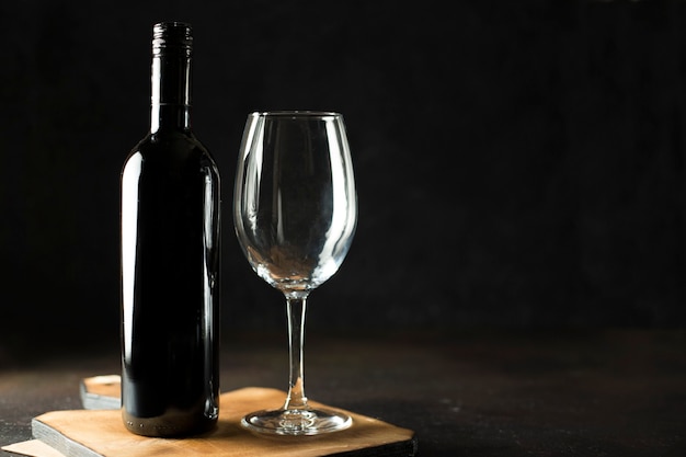 Fles rode wijn en een glas leeg op de houten