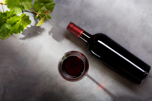 fles rode wijn en een glas op tafel