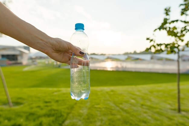 Fles water in vrouwelijke hand, exemplaarruimte