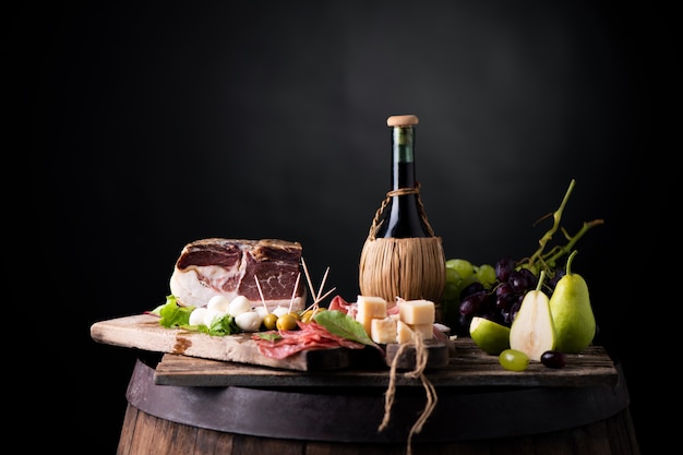 Fles wijn op een tafel met rustiek traditioneel Italiaans eten. Verse typische Italiaanse levensstijl