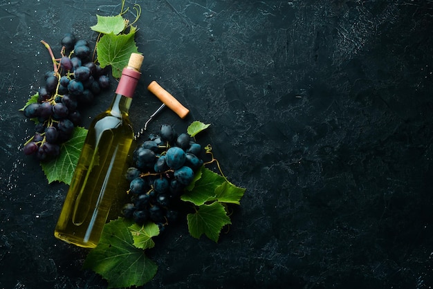 Fles witte wijn en verse druiven op een zwarte stenen tafel bovenaanzicht vrije ruimte voor uw tekst