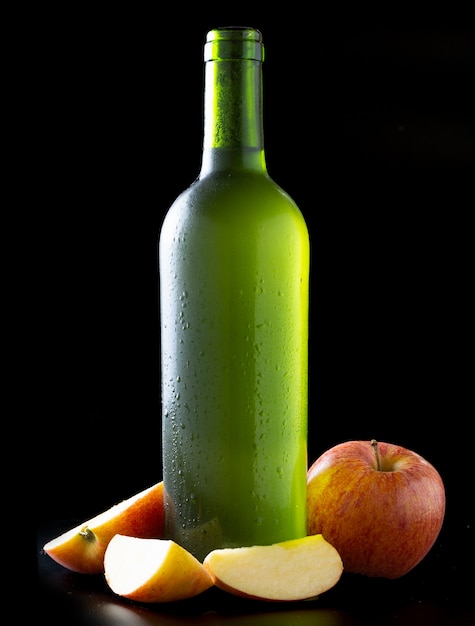 Fles zeer koude cider met appels met zwarte achtergrond