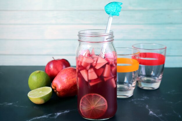 Fles zelfgemaakte rode wijn Sangria met twee glazen en fruit op tafel