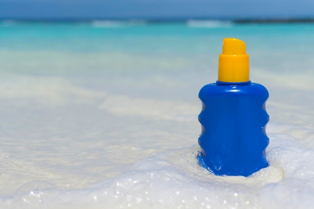 Fles zonnebrandcrème bescherming op een tropisch strand