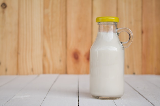 Flesglas Melk op een houten tafel.