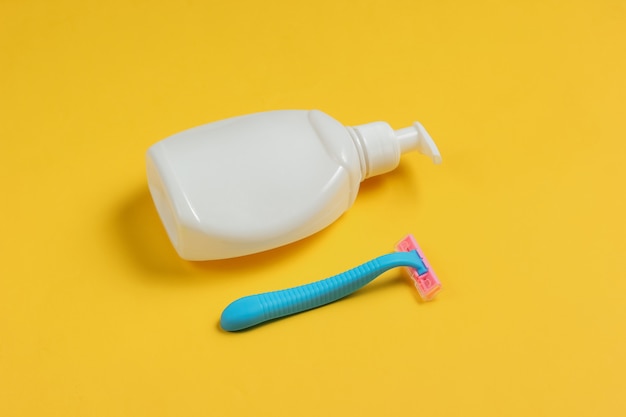 Flesje gel voor ontharing, scheermesje op geel papier