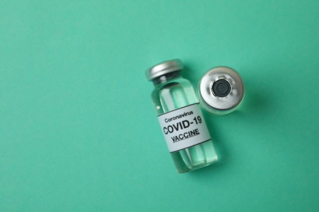 Flesjes Covid - 19 vaccin op muntachtergrond