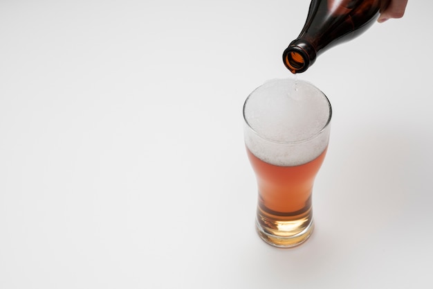 Foto flessen gietend bier in glas met exemplaarruimte