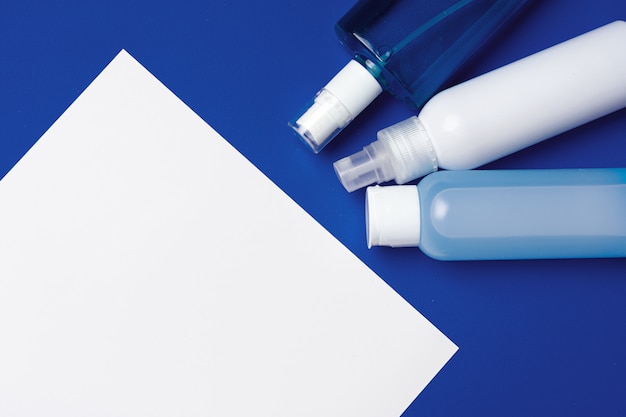 Flessen met antibacterieel handdesinfecterend middel op blauw met exemplaarruimte