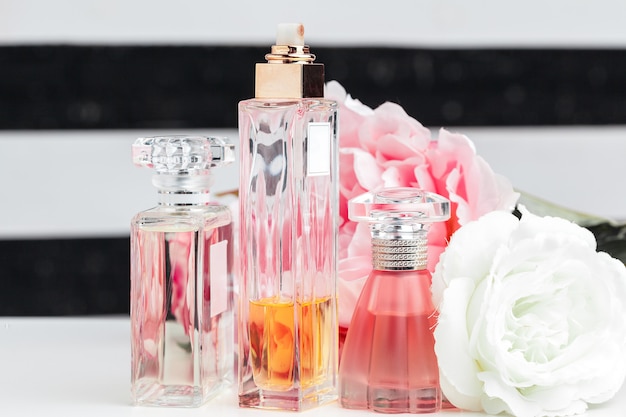 Foto flessen parfum met bloemen op wit