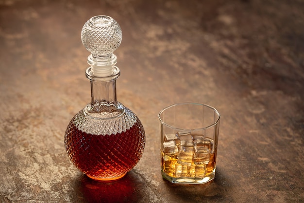 Flessenwhisky en Glas wisky met ijs op zwarte achtergrond