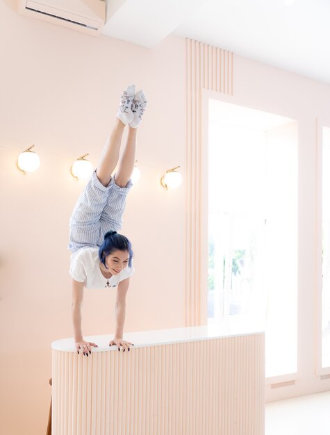 Flexibel meisje oefent zich uit en handstand thuis concept van individualiteit creativiteit