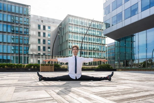 Flexibele en coole zakenman die acrobatische truc doet