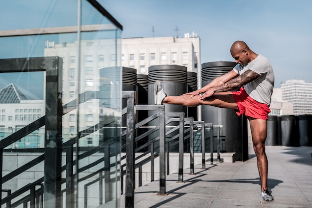 Flexibility exercise. handsome serious sportsman trying to
touch his toes whilw doing a flexibility exercise