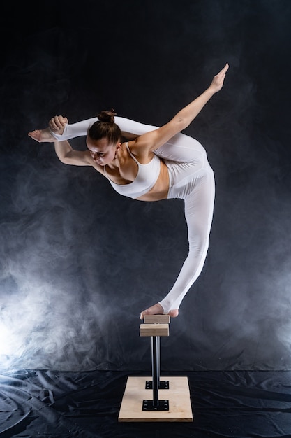 Flexible circus artist - female acrobat doing handstand on the\
back and smoker