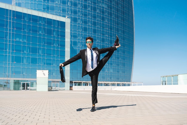 Flexible and cool businessman doing acrobatic trick