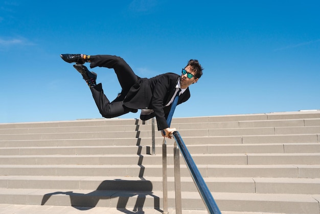 Flexible and cool businessman doing acrobatic trick