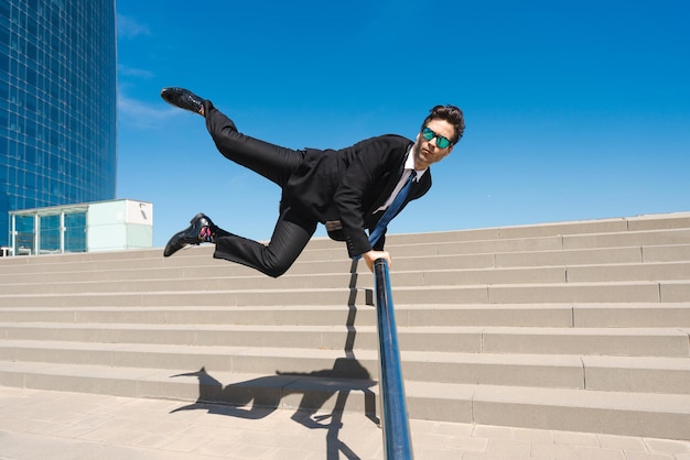 Flexible and cool businessman doing acrobatic trick