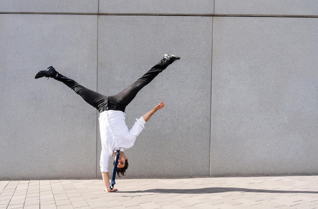 Photo flexible and cool businessman doing acrobatic trick