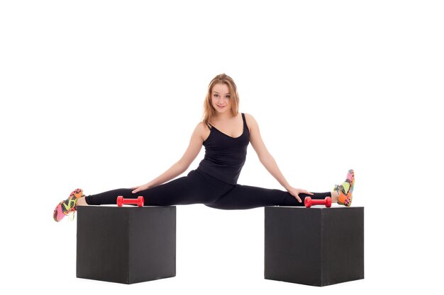 Photo flexible girl doing gymnastic splits on cubes