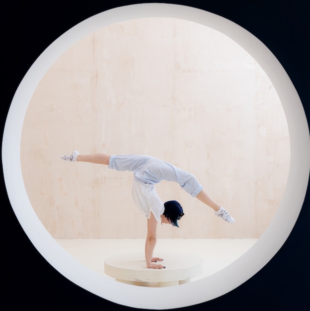 Photo flexible girl doing stretching and handstand in studio concept of individuality creativity and selfc...