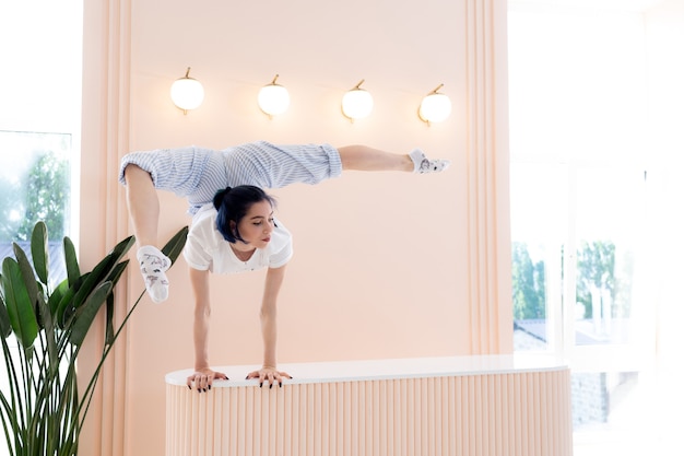 Flexible girl practice stretching and handstand at home concept of quarantine time during self isola...