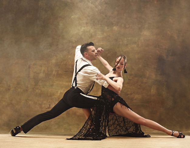 Flexible young modern dance couple posing in studio.