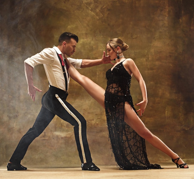 Flexible young modern dance couple posing in studio.