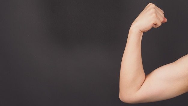 The Flexing or Strong Arm Hand Sign on black background.