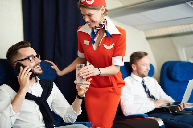 Photo flight attendant serving drinks