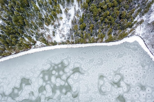 Flight over frozen lake in forest Austria