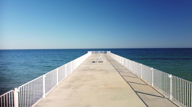 Flight over the pier in the sea on a sunny day