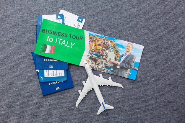 Flight tickets with passports, model of airplane and map on gray background.