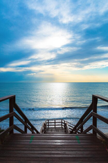 A flight of wooden stairs going down with angry sea waves in the bottom High quality photo