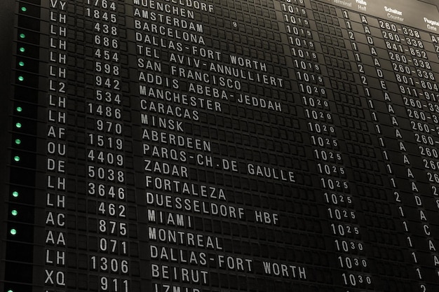 Flights timetable in airport terminal some flights are delayed\
traveling around the world by airplane time schedule with gate and\
checkin number