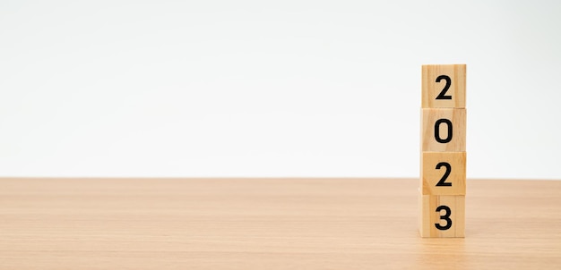 Flip block with the number 2023 on top on a wooden table with a white background