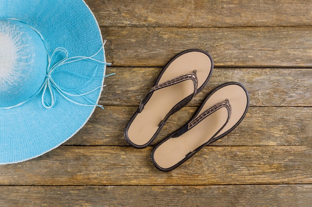 Photo flip flops and hat on wooden floor