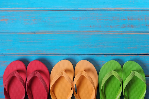 Photo flip flops in a row old weathered blue beach wood background