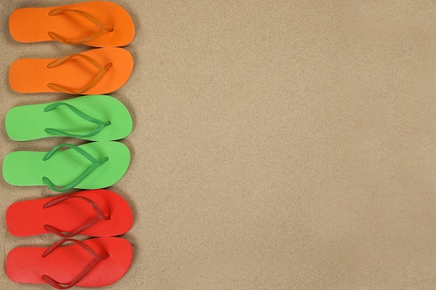 Сандалии Flip Flops на пляже летом на песке с копирайтом