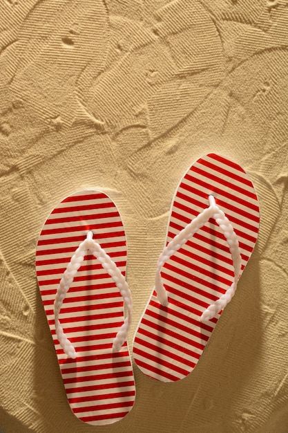 Flip flops on a sandy beach, sunset, top view