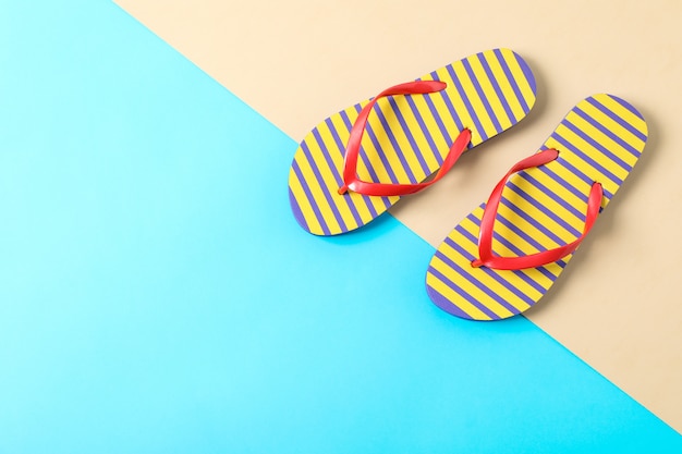 Flip flops on two tone background, space for text and top view. Summer vacation concept