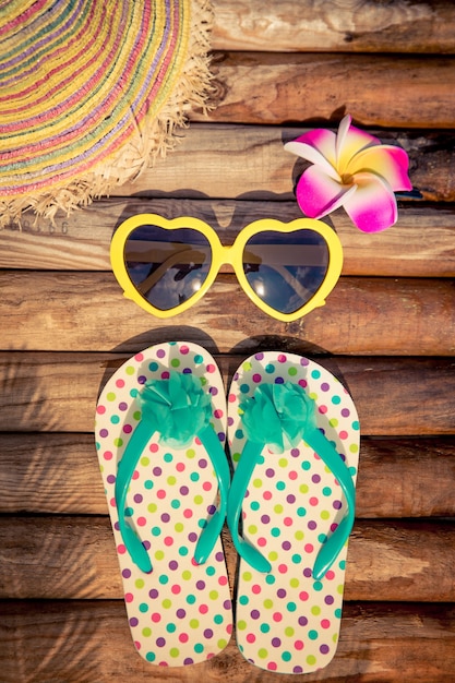 Flipflops on wood against blue water Summer vacation concept