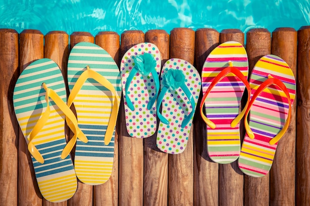 Flipflops on wood against blue water Summer vacation concept